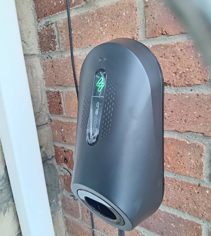 Black EV charger on a brick wall