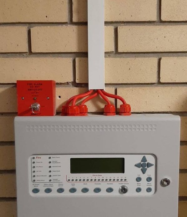 Fire alarm control panel on a brick wall